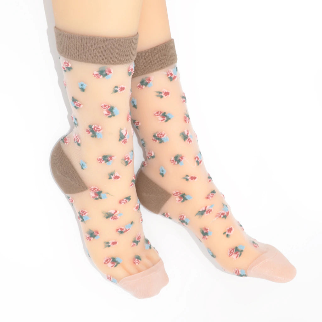 A pair of sheer beige ankle socks with a small pink and blue floral print, featuring solid taupe-brown ribbed cuffs and toes, shown on a white background.