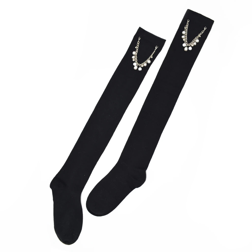 Black knee-high socks with pearl embellishments on a white background