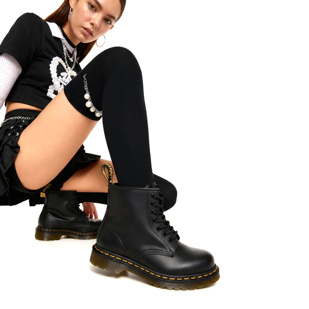 Person wearing black boots with a white background